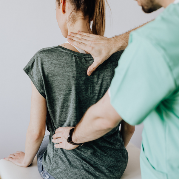 chiropractor adjusting client's spine